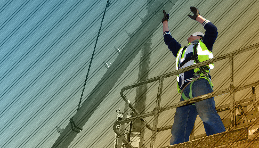 Construction worker on scaffold directing a crane load